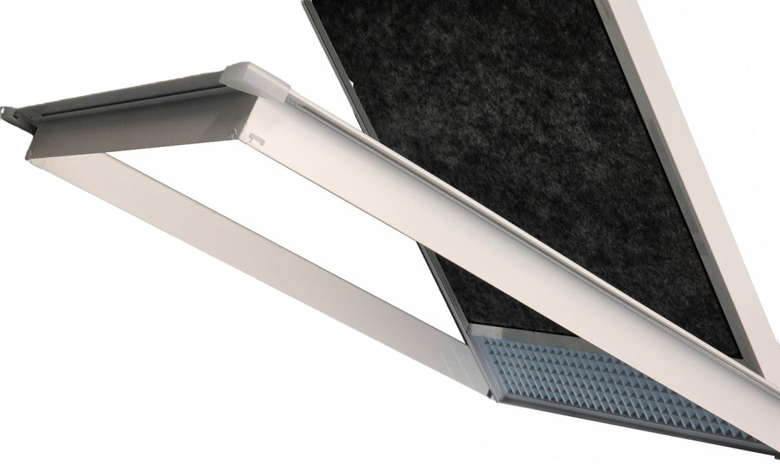A close-up of a modern linear LED light fixture with a white frame, showing the illuminated diffuser panel and the textured black filter mesh behind it.

